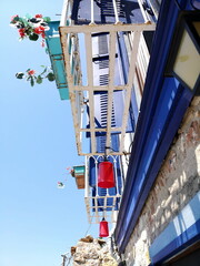 Rote Lampen am Balkon eines sanierten Altbau in Weiß und Blau im Sommer bei blauem Himmel und...