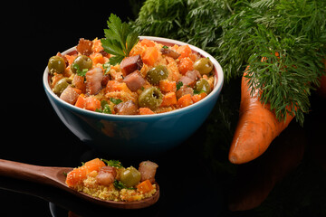 carrot farofa with bacon and olives in a bowl on a black background