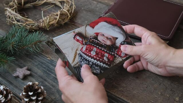 Christmas photo printing. Woman hands browsing Christmas printed photos.