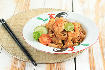 Seafood Kwetiau Goreng with Egg, Shrimps, Fish Meatball, and Lime.