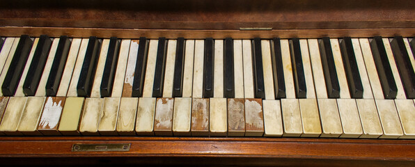Old wooden upright grand piano black and white keys with detailed real ivory inlays with some...