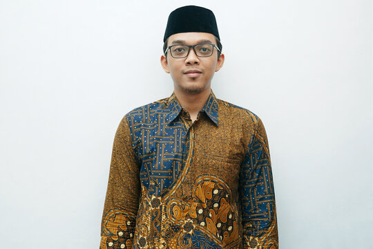 Portrait of Asian Indonesian man wearing batik shirt traditional cloth and black peci or songkok