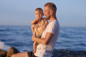 Father and son on the seashore at sunset. Happy family.