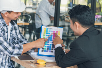 Asian interior designer team partner engineer brainstorming choosing color swatch. Engineer man...