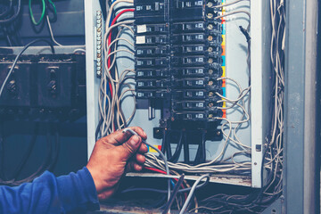 Electrical mechanic technician check wire electric cabinet. Inspector men hands working switchboard machinery maintenance service. Electrician circuit repair voltage operation. Men hands fix breaker