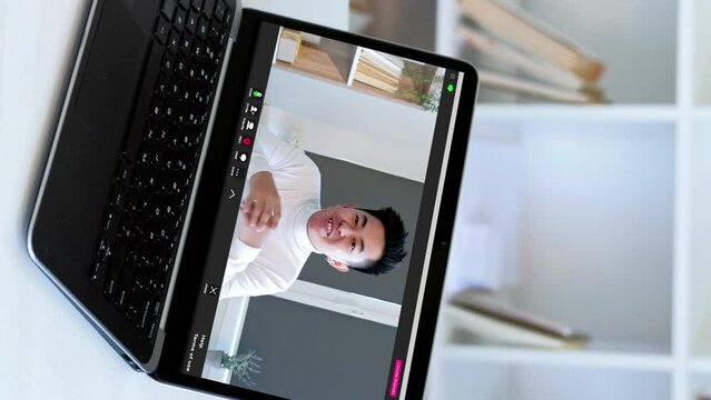 Vertical video. Web communication. Digital conference. Confident CEO business man speaking on laptop screen at virtual home office workplace.