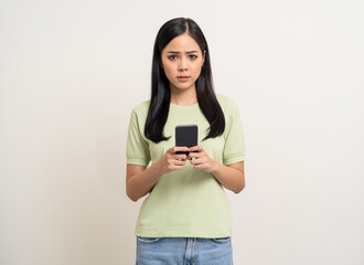 Pretty young asian woman using smartphone feeling upset confused bad depressed emotional standing...