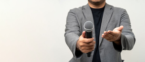 Close up businessman speaker hand holding High quality dynamic microphone and singing song or speaking talking with people on isolated white background. Male testing microphone voice for interview