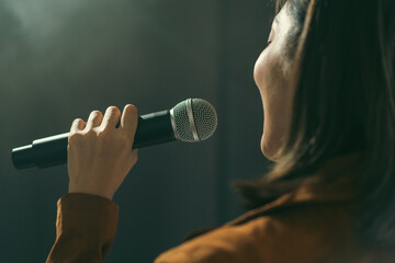 Close up woman hand holding High quality dynamic microphone and singing song or speaking talking...