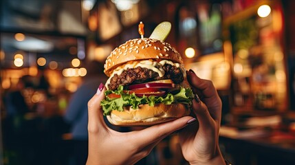 Female hand with delicious burger at burger shop - obrazy, fototapety, plakaty