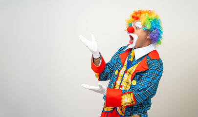 Mr Clown. Portrait of Funny comedian face Clown man in colorful uniform pointing finger to copy...