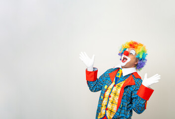 Mr Clown. Portrait of Funny shocked face comedian Clown man in colorful costume wearing wig hands palm up to copy space. Happy expression amazed bozo in various pose on isolated background.