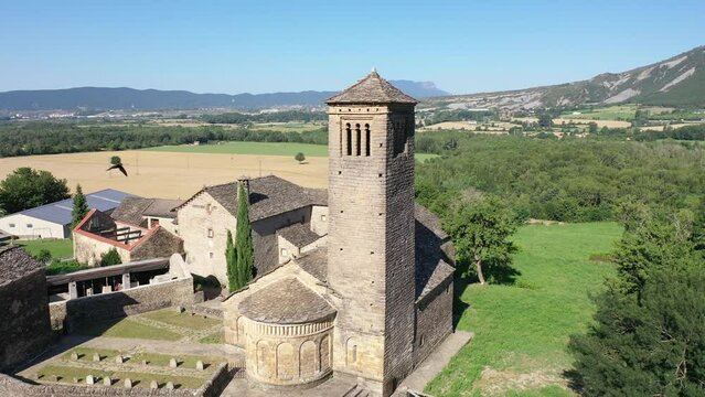 Aerial view of bell tower and apse of the Mozarab Pre-Romanesque or Romanesque Church of San Pedro de Larrede in the Serrablo Region. Aragon. Spain. High quality 4k footage