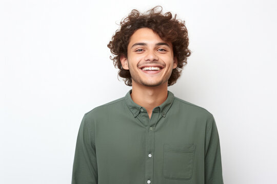 Picture of man with curly hair, wearing green shirt and smiling. This versatile image can be used for various purposes.