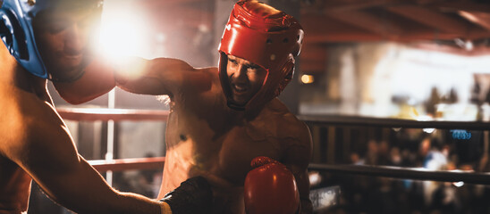 Two athletic and muscular body boxers with safety helmet or boxing head guard face off in fierce...