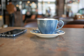 late coffee and a smart phone on cafe table 