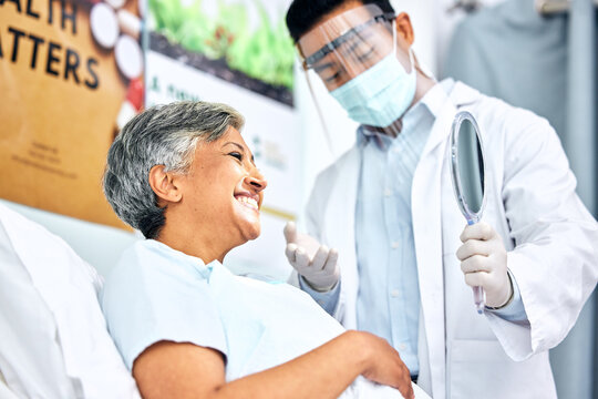 Dentist In Mask, Patient With Smile And Mirror For Healthcare, Cleaning And Hygiene For Teeth. Happy Woman In Chair, Dental Care Technician And Safety In Surgery On Mouth, Professional Doctors Office