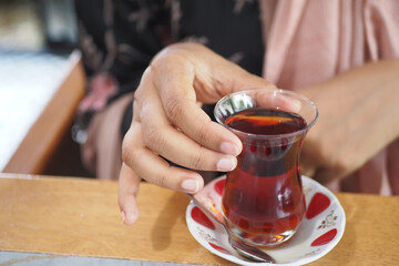 women drinking Traditional turkish tea on white table .