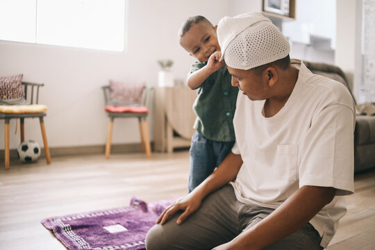 Asian Muslim father and son ready to praying jamaah together at home