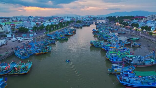 Drone view basket boat moving through fishing boats are nailing side by side on the Ca Ty river, Phan Thiet city, Binh Thuan province, central Vietnam