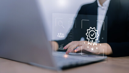 Businesswoman using laptop computer with quality assurance and document icon for ISO or International Standard Organisation which related quality control and continuous improvement concept.