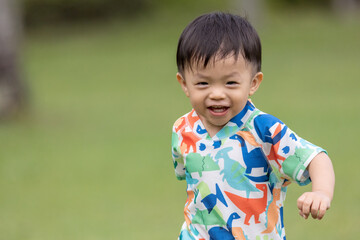 Portrait image of happy little boy have a good time with nature green background