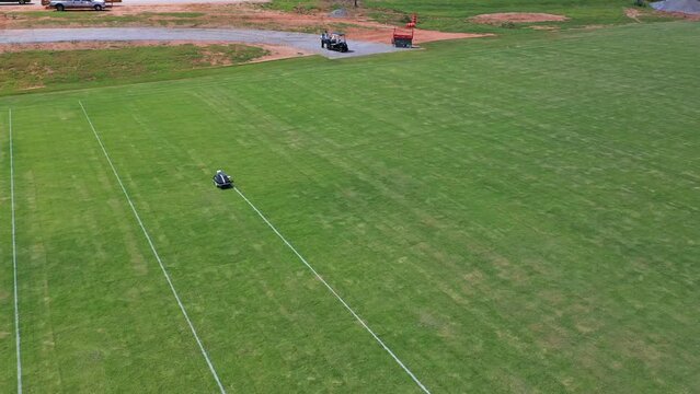 Aerial shot of a robot painting white lines on a playing field.
