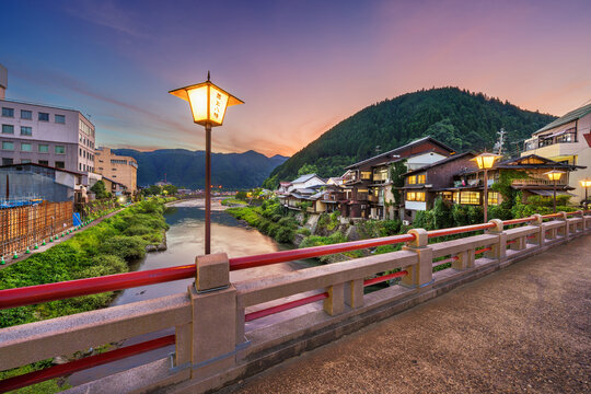 Gujo Hachiman, Japan hot springs town at dusk over the Yoshida River. (Text on Lanterns reads: Gujo Hachiman)