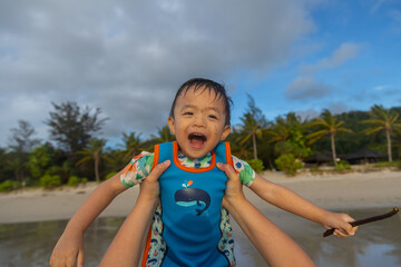 Happy Asian Chinese child playing in the beach. Kid having fun outdoors. Summer vacation and healthy lifestyle concept