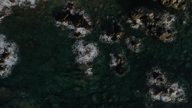 West Crete fly over though rocks and ocean during golden hour sunset phase