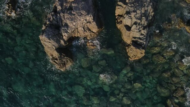 West Crete fly over though rocks and ocean during golden hour sunset phase