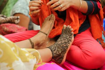  Indian mehndi artist making henna design bridal foot