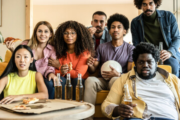 group of friends at home watching soccer game drinking beers