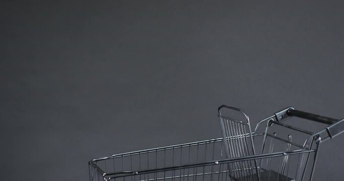 Video of shopping trolley with copy space over grey background