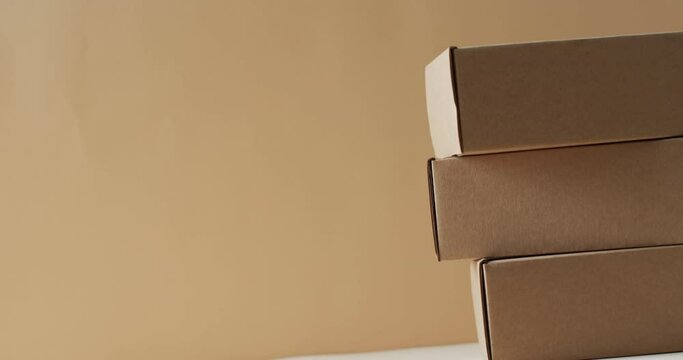 Video of stacked cardboard boxes with copy space over brown background
