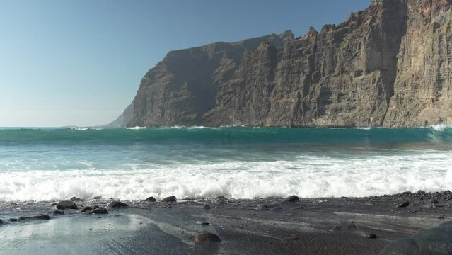 Stepped cliff beach waves of Playa de los Guios Spain 