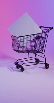 Vertical video of shopping trolley with white canvas with copy space over pink neon background