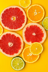 Cut pieces of citrus fruits on orange background