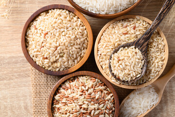 Thai brown rice seed in wooden bowl with spoon, Organic rice, Healthy food ingredient