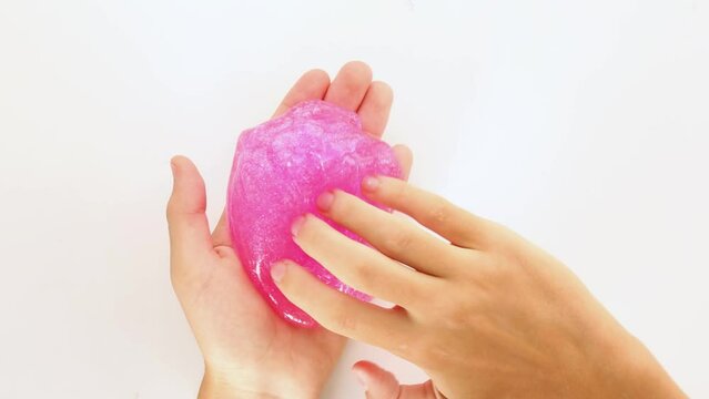 Asmr. A man in his palms presses a pink, jelly-like slime on a white background