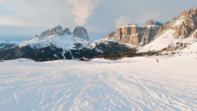 First-person view FPV first-person point of view POV of alpine skiing in Dolomites. Ski resort piste with people skiing in Dolomites in Italy. Ski area Belvedere. Canazei, Italy, Europe