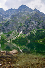 Amazing view on mountains range near beautiful lake at summer day. Tatra National Park in Poland. Panoramic view on Morskie Oko or Sea Eye lake in Five lakes valley