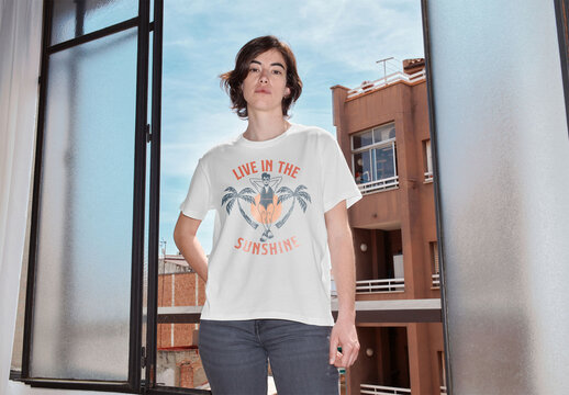 Mockup of woman wearing t-shirt with customizable color by open window, camera flash
