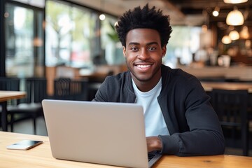 Portrait of Cheerful Black Male Student Learning Online in Coffee Shop, Young African American Man Studies with Laptop in Cafe, Doing Homework