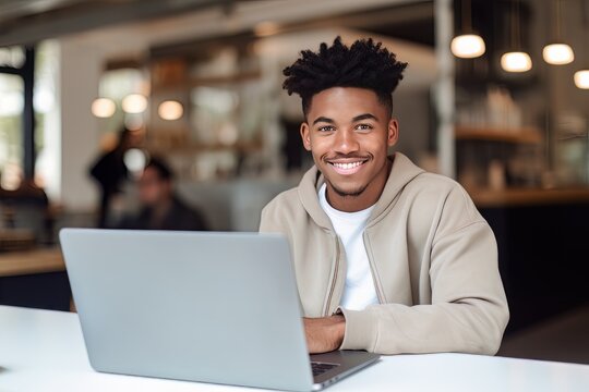 Portrait of Cheerful Black Male Student Learning Online in Coffee Shop, Young African American Man Studies with Laptop in Cafe, Doing Homework