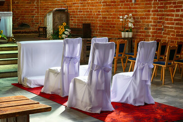 Kościół katolicki z widocznym ołtarzem i krzesłami dla pary młodej. ślub.  - obrazy, fototapety, plakaty