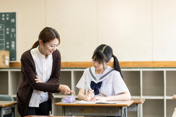 授業を受ける女子中学生と女性教師