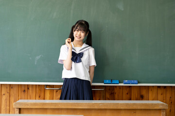 笑顔で黒板の前に立つ女子中学生