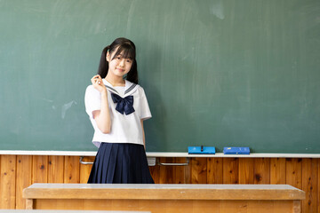 学校の教室の黒板と中学生の女の子