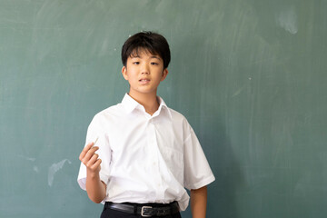 教室の黒板の前に立つ男子中学生